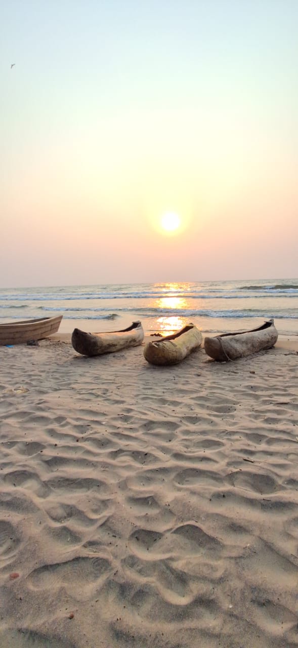 Dugout canoes resting on the sandy shore at sunset on Lake Malawi
