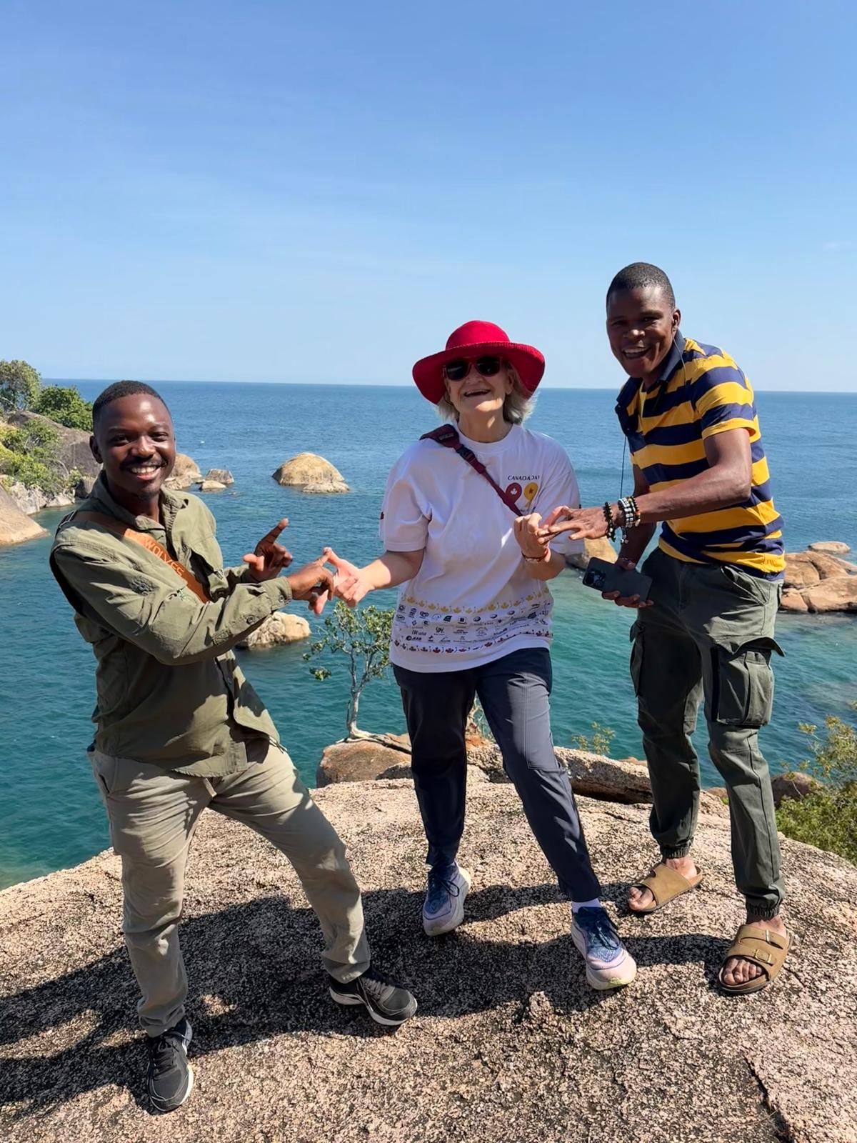Guides and a guest posing on granite rocks above Lake Malawi