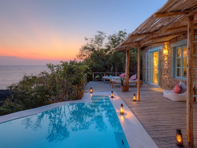 Lakeside lodge terrace with a pool at dusk