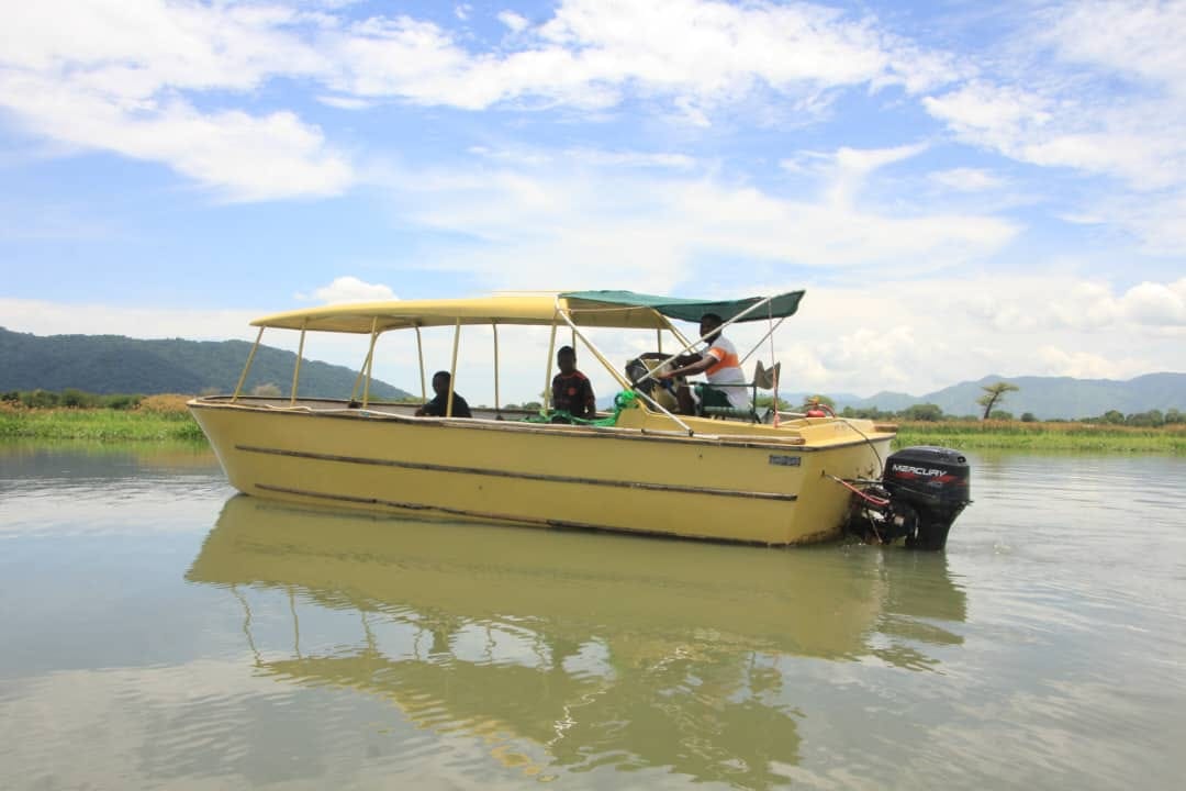 Yellow safari boat with guide and guests on a calm river