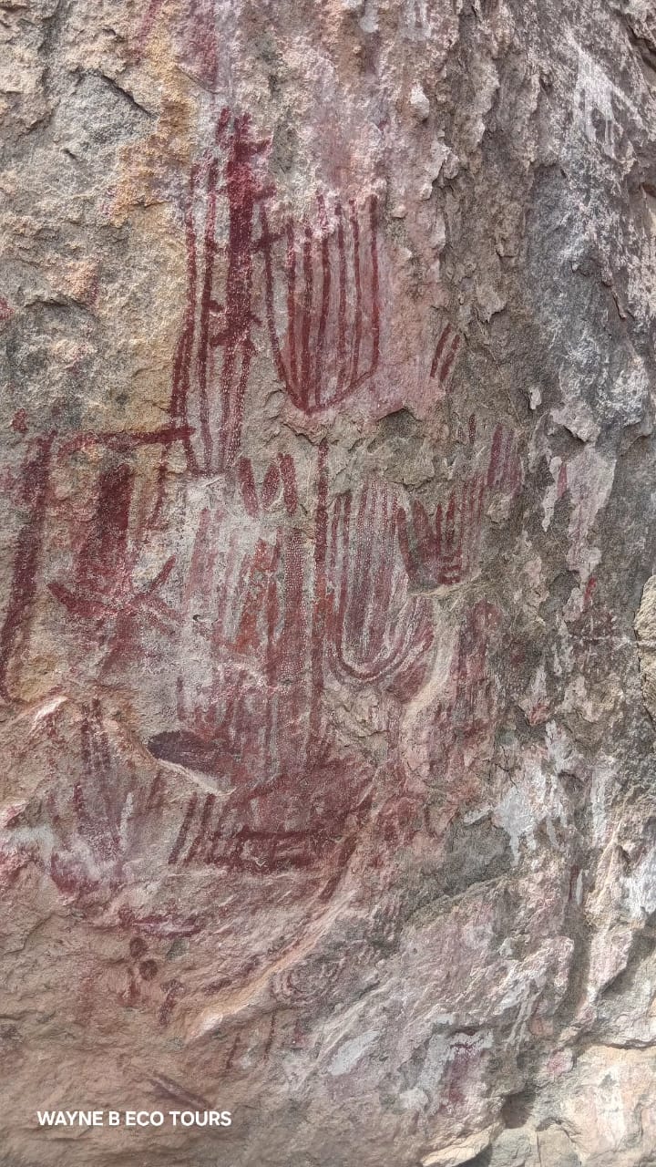 Red ochre rock paintings on a granite shelter wall